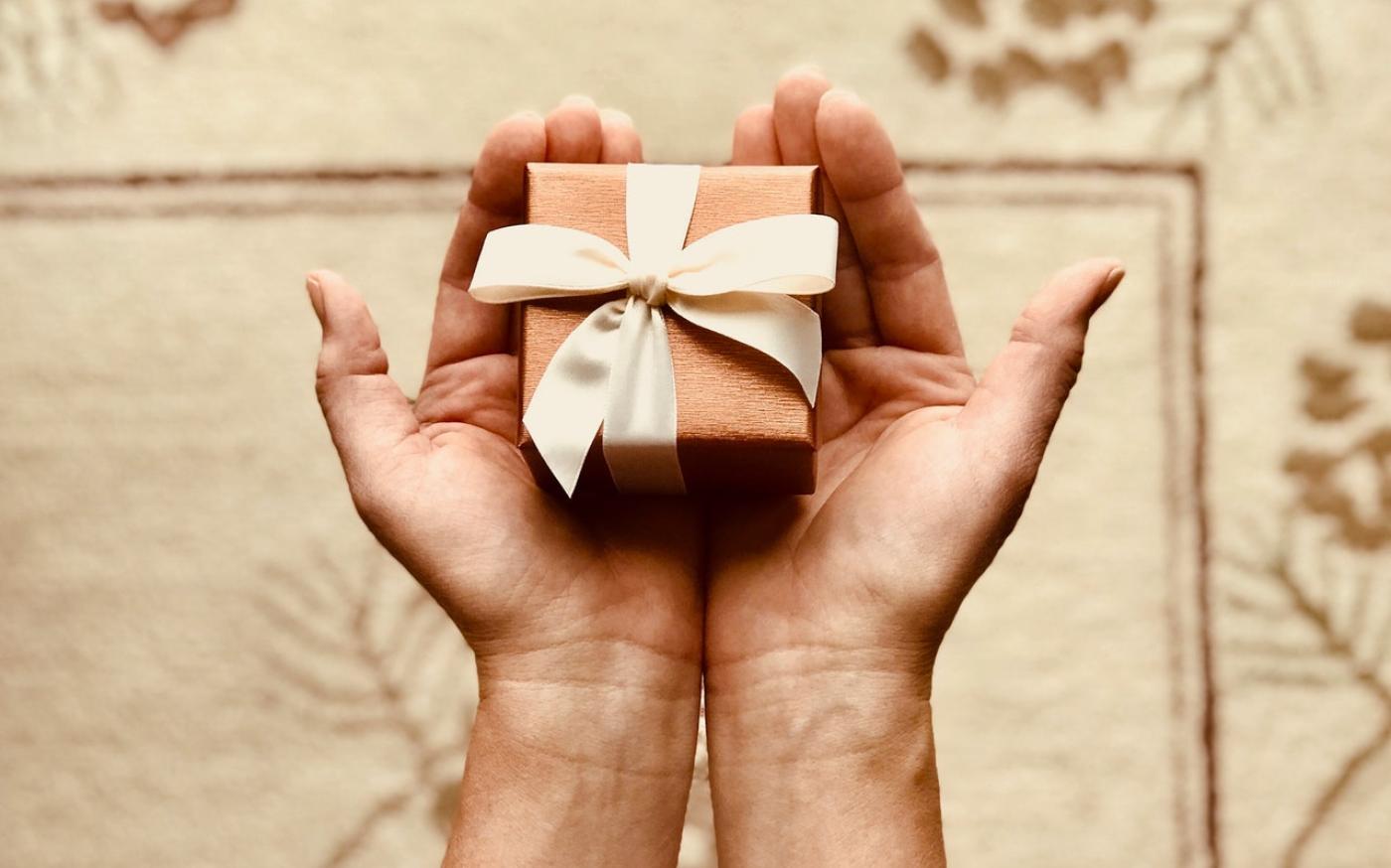 Hands holding a small wrapped present